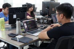 Азиат Outsource команда разработчика сидя на компьтер-книжке стола работая стоковое фото Азиат Outsource команда разработчика сидя на компьтер-книжке стола работая стоковое фото