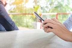 Азиатский человек держа телефон, используя smartphone пока его деловой партнер говоря на телефоне в предпосылке стоковое фото rf Азиатский человек держа телефон, используя smartphone пока его деловой партнер говоря на телефоне в предпосылке стоковое фото rf