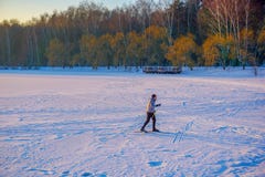 Активные беговые лыжи молодого человека на огромном замороженном озере во время прекрасного захода солнца зимы стоковое фото Активные беговые лыжи молодого человека на огромном замороженном озере во время прекрасного захода солнца зимы стоковое фото