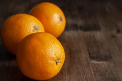 3 апельсина на темной деревянной предпосылке стоковые изображения rf 3 апельсина на темной деревянной предпосылке стоковые изображения rf