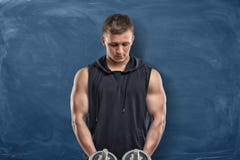 Атлетический человек стоит с сжатиями в его руках и классн классном за им Стоковые Изображения Атлетический человек стоит с сжатиями в его руках и классн классном за им Стоковые Изображения