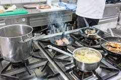 Баки и лотки на плите в кухне ресторана, деятельности i шеф-повара стоковая фотография Баки и лотки на плите в кухне ресторана, деятельности i шеф-повара стоковая фотография