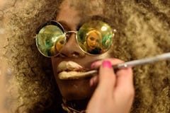 Белокурые губы золота картины художника с tassel отразили в солнечных очках моды африканских или черного американского носить мод стоковое фото Белокурые губы золота картины художника с tassel отразили в солнечных очках моды африканских или черного американского носить мод стоковое фото