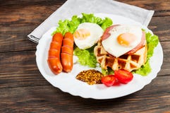 Бельгийский waffle с яичком и сосиской на деревянной таблице Стоковое Фото Бельгийский waffle с яичком и сосиской на деревянной таблице Стоковое Фото