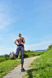 Бегун маленькой девочки jogging на горной тропе в красивом ландшафте Стоковая Фотография Бегун маленькой девочки jogging на горной тропе в красивом ландшафте Стоковая Фотография