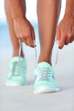 Бегун спортсменки получая готовые связывая идущие ботинки на пляже стоковая фотография rf Бегун спортсменки получая готовые связывая идущие ботинки на пляже стоковая фотография rf