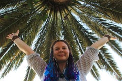 Белая девушка с голубыми улыбками и волнами отрезков провода ее руки на предпосылке ладони стоковое изображение Белая девушка с голубыми улыбками и волнами отрезков провода ее руки на предпосылке ладони стоковое изображение