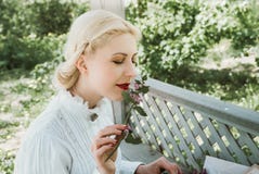Белокурая девушка пахнуть цветком стоковые фотографии rf Белокурая девушка пахнуть цветком стоковые фотографии rf