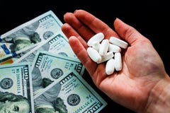 Белые таблетки в руке и dolary на черной предпосылке Много психоделические таблетки стоковая фотография rf Белые таблетки в руке и dolary на черной предпосылке Много психоделические таблетки стоковая фотография rf