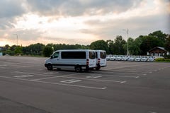 Белые фургоны припаркованные на месте для парковки асфальта стоковые фото Белые фургоны припаркованные на месте для парковки асфальта стоковые фото