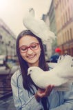 Белый голубь сидит на голове смеясь над девушки Развлечения для туристов в Санкт-Петербурге стоковое изображение Белый голубь сидит на голове смеясь над девушки Развлечения для туристов в Санкт-Петербурге стоковое изображение