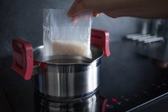 Белый испаренный рис в сумках части для варить Варящ рис, женщина клад стоковые изображения Белый испаренный рис в сумках части для варить Варящ рис, женщина клад стоковые изображения
