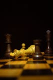 Белый король теряет к ответной части проверки в игре в шахматы на деревянной доске стоковое фото rf Белый король теряет к ответной части проверки в игре в шахматы на деревянной доске стоковое фото rf