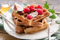 Бельгийские waffles с полениками, медом и смоквами стоковые изображения rf Бельгийские waffles с полениками, медом и смоквами стоковые изображения rf