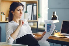 Беременная бизнес-леди работая на материнстве офиса сидя проводящ отчет стоковые фотографии rf Беременная бизнес-леди работая на материнстве офиса сидя проводящ отчет стоковые фотографии rf