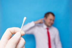 Беруш в ухе молодого человека, доктор держит в его руке выход для earwax, пробирку хлопка стоковое фото Беруш в ухе молодого человека, доктор держит в его руке выход для earwax, пробирку хлопка стоковое фото