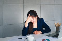 Бизнес-леди азиатских длинных волос красивая в напряжении костюма сини военно-морского флота с головной болью util работы в ее оф стоковая фотография rf Бизнес-леди азиатских длинных волос красивая в напряжении костюма сини военно-морского флота с головной болью util работы в ее оф стоковая фотография rf