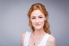Бизнес-леди портрета крупного плана молодая, красивая, студент с lred, вьющиеся волосы и веснушки на стороне на серой предпосылке стоковая фотография rf Бизнес-леди портрета крупного плана молодая, красивая, студент с lred, вьющиеся волосы и веснушки на стороне на серой предпосылке стоковая фотография rf