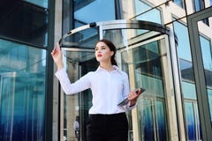 Бизнес-леди щелкает с указательным пальцем на виртуальном экране на предпосылке офисного здания стоковое изображение Бизнес-леди щелкает с указательным пальцем на виртуальном экране на предпосылке офисного здания стоковое изображение