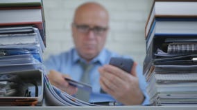Бизнесмен в неясном изображении делает онлайн-платежи с картой смартфона и банка стоковое изображение rf Бизнесмен в неясном изображении делает онлайн-платежи с картой смартфона и банка стоковое изображение rf
