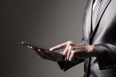 Бизнесмен в сером костюме держа таблетку касаясь социальной концепции технологии средств массовой информации стоковое фото Бизнесмен в сером костюме держа таблетку касаясь социальной концепции технологии средств массовой информации стоковое фото