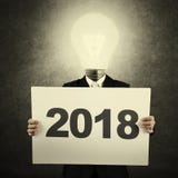 Бизнесмен держа 2018 на афише Стоковые Изображения Бизнесмен держа 2018 на афише Стоковые Изображения