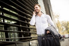 Бизнесмен молодого успешного человека исполнительный используя его передвижной cel стоковая фотография rf Бизнесмен молодого успешного человека исполнительный используя его передвижной cel стоковая фотография rf