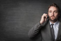 Бизнесмен отвечая по телефону шнура стоковое изображение Бизнесмен отвечая по телефону шнура стоковое изображение