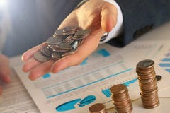 Бизнесмен руки кладя деньги штыря в свинью стоковое фото rf Бизнесмен руки кладя деньги штыря в свинью стоковое фото rf