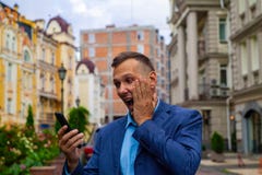 Бизнесмен смотрит в телефоне тесты удар и сюрприз стоковое фото Бизнесмен смотрит в телефоне тесты удар и сюрприз стоковое фото