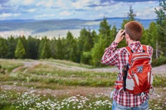 Бинокли мужского путешественника наблюдая в расстояние против леса и облачного неба стоковая фотография Бинокли мужского путешественника наблюдая в расстояние против леса и облачного неба стоковая фотография