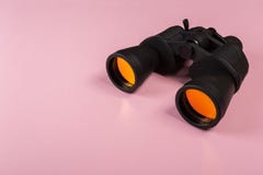 Бинокли с оранжевым объективом на розовой предпосылке стоковое фото rf Бинокли с оранжевым объективом на розовой предпосылке стоковое фото rf