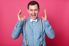 Близкий поднимающий вверх портрет студии радостного красивого уверенного стильного человека Удачливый парень поднимает руки вверх стоковое фото Близкий поднимающий вверх портрет студии радостного красивого уверенного стильного человека Удачливый парень поднимает руки вверх стоковое фото