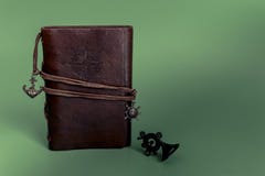 Блокнот дневника Handmade бумаги в коричневом кожаном случае на зеленой предпосылке рождества стоковое изображение rf Блокнот дневника Handmade бумаги в коричневом кожаном случае на зеленой предпосылке рождества стоковое изображение rf