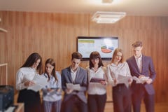 Большая команда людей работает на одной таблице для ноутбуков, планше стоковое изображение rf Большая команда людей работает на одной таблице для ноутбуков, планше стоковое изображение rf