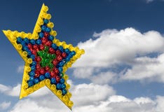 Большая красочная звезда по-разному цветных ламп изъятых перед голубым небом с облаками иллюстрация штока Большая красочная звезда по-разному цветных ламп изъятых перед голубым небом с облаками иллюстрация штока