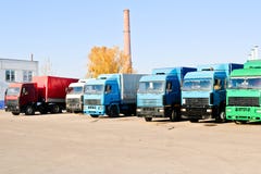 Большие тяжелые тележки груза с кабинами и трейлерами стоят в ряд готовыми для доставки груза на промышленном рафинадном заводе стоковое фото Большие тяжелые тележки груза с кабинами и трейлерами стоят в ряд готовыми для доставки груза на промышленном рафинадном заводе стоковое фото
