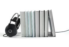 Большие черные наушники около стога книг на белой предпосылке Аудио концепция книги r стоковое изображение Большие черные наушники около стога книг на белой предпосылке Аудио концепция книги r стоковое изображение