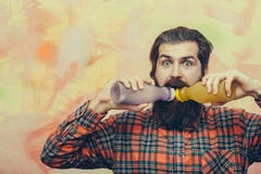 Бородатый человек с бородой выпивая от 2 пластичных бутылок стоковая фотография rf Бородатый человек с бородой выпивая от 2 пластичных бутылок стоковая фотография rf