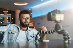 Бородатый мужской видео- блоггер создает видео- содержание для его канала Vlogger человека сбрасывает на камере с треногой стоковые фото Бородатый мужской видео- блоггер создает видео- содержание для его канала Vlogger человека сбрасывает на камере с треногой стоковые фото