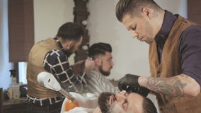 Брить процесс бород в парикмахерскае Мастер делает клиента бороды стрижки с винтажной прямой бритвой видеоматериал Брить процесс бород в парикмахерскае Мастер делает клиента бороды стрижки с винтажной прямой бритвой видеоматериал