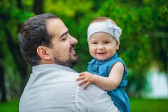 Будьте отцом держать его молодую дочь в парке стоковая фотография Будьте отцом держать его молодую дочь в парке стоковая фотография
