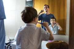 Будьте отцом учащ сына как почистить его зубы щеткой стоковые изображения Будьте отцом учащ сына как почистить его зубы щеткой стоковые изображения