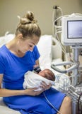 Будьте матерью держать ее newborn недоношенный ребенка в больнице стоковое фото rf Будьте матерью держать ее newborn недоношенный ребенка в больнице стоковое фото rf