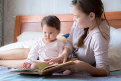 Будьте матерью читать книгу к ее ребенку на кровати Сказка на ночь как учащ прочитайте к стоковое изображение Будьте матерью читать книгу к ее ребенку на кровати Сказка на ночь как учащ прочитайте к стоковое изображение