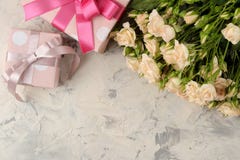 Букет красивых нежных мини роз и подарочной коробки на светлой конкретной предпосылке установьте текст праздники presents стоковые фотографии rf Букет красивых нежных мини роз и подарочной коробки на светлой конкретной предпосылке установьте текст праздники presents стоковые фотографии rf