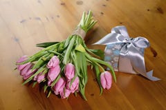 Букет пинка тюльпанов на красивых деревянных предпосылке и подарке Стоковое фото RF Букет пинка тюльпанов на красивых деревянных предпосылке и подарке Стоковое фото RF
