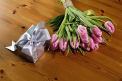 Букет пинка тюльпанов на красивых деревянных предпосылке и подарке Стоковое Фото Букет пинка тюльпанов на красивых деревянных предпосылке и подарке Стоковое Фото
