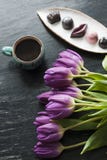 Букет тюльпанов, черного кофе и очень вкусной handmade конфеты Стоковые Фотографии RF Букет тюльпанов, черного кофе и очень вкусной handmade конфеты Стоковые Фотографии RF