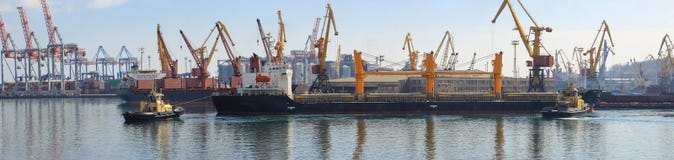 Буксир на смычке грузового корабля, помогая сосуду для того чтобы провести маневр в морском порте стоковое фото Буксир на смычке грузового корабля, помогая сосуду для того чтобы провести маневр в морском порте стоковое фото
